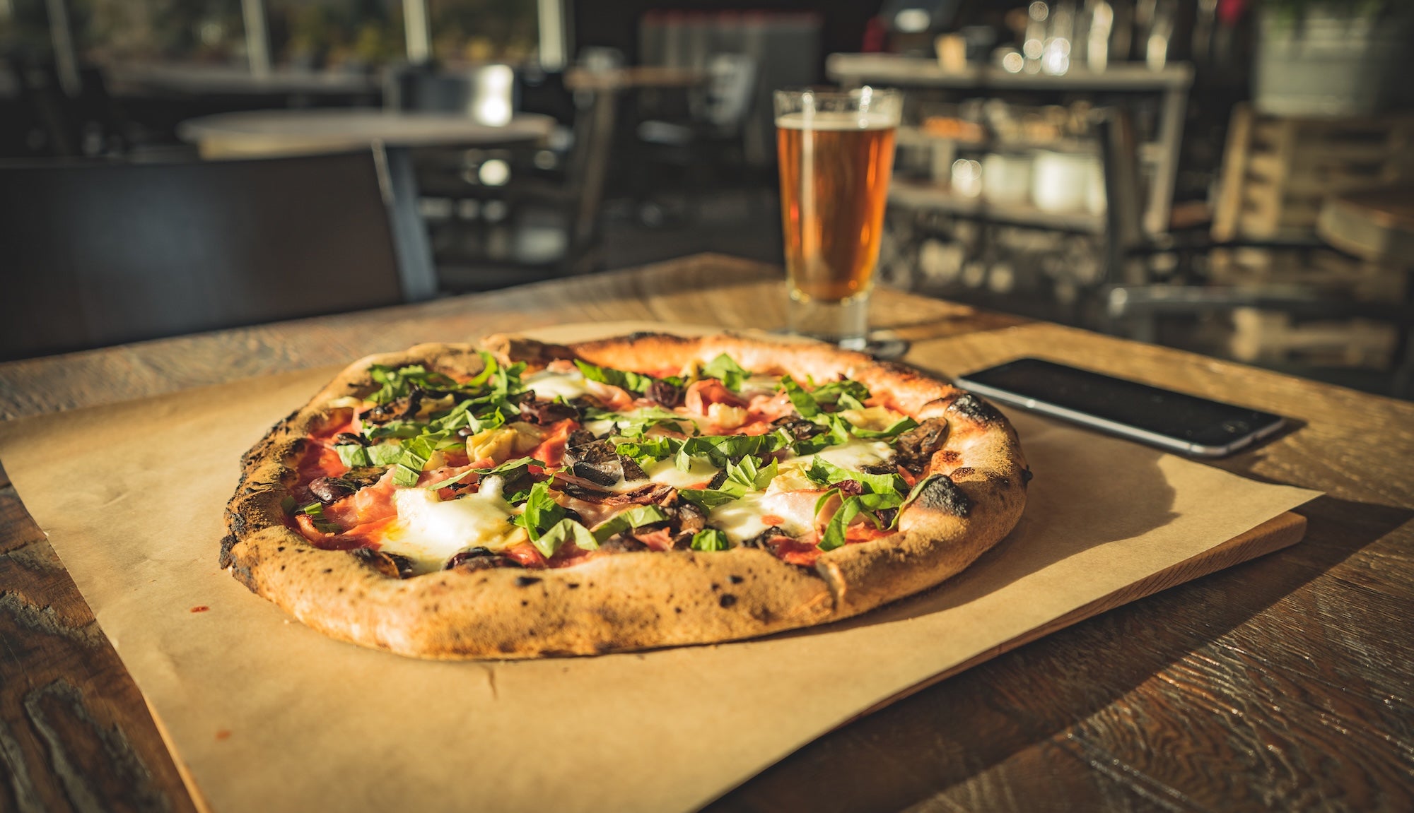 pizza on a table with a beer